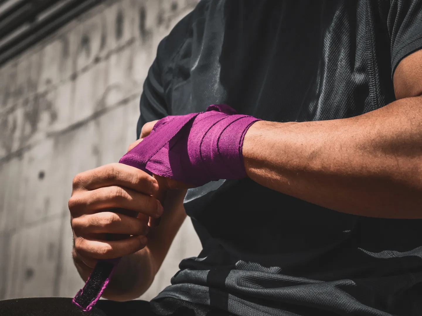 Athlete wrapping hands before training session for concussion risk management